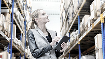 Woman in a warehouse with clipboard being inspired