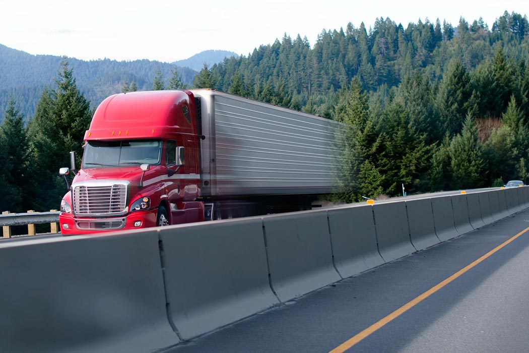Temperature controlled truck on highway behind median barrier
