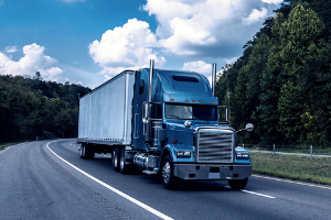 Blue cab truck rounding corner of freeway