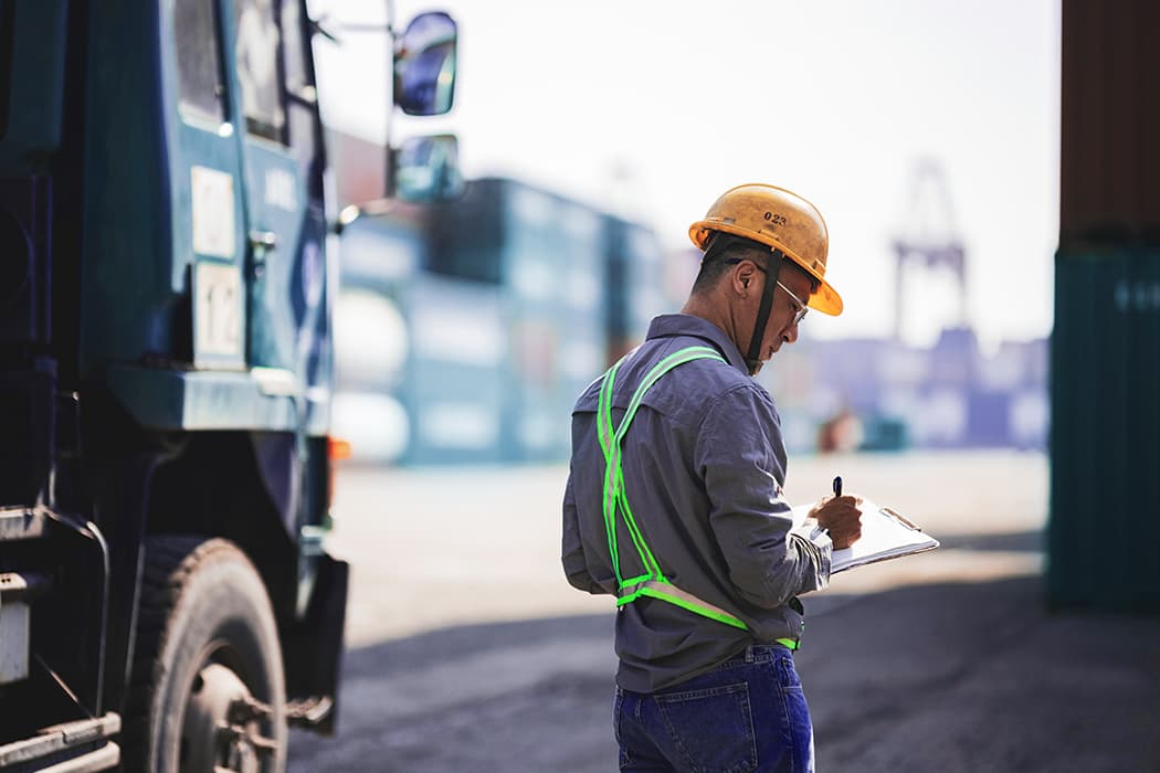 Port worker checking LCL containers