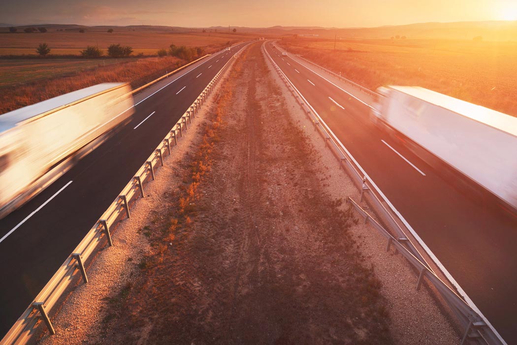 Speeding trucks driving at sunset