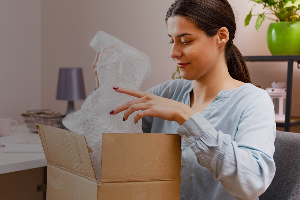 Woman opening small parcel packaging