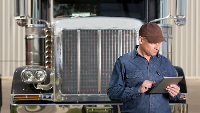 semi driver checking an app on a tablet