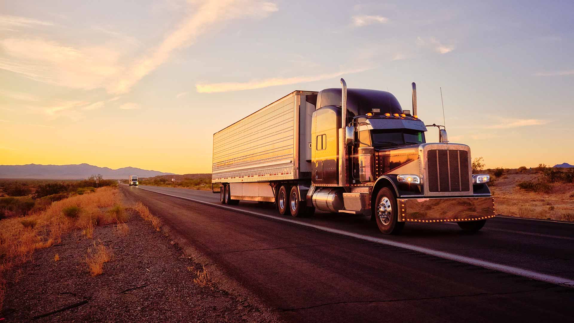 Semi truck traveling on 2-lane highway at dusk