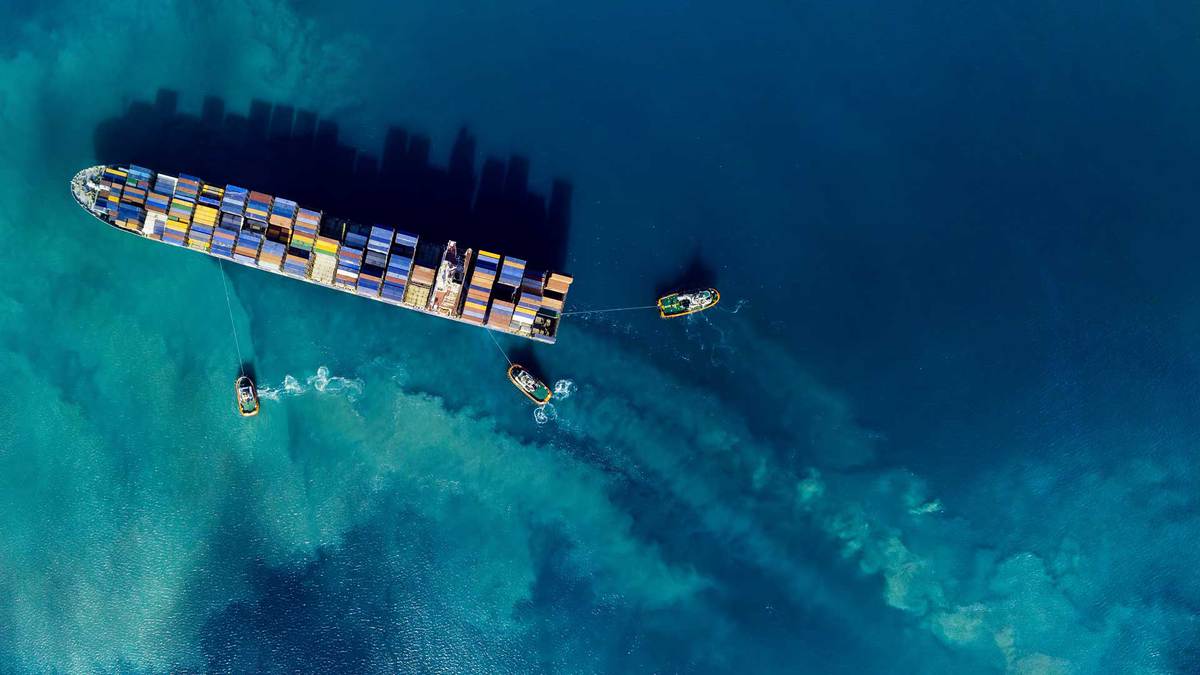Aerial view of a cargo ship in the ocean making a left turn