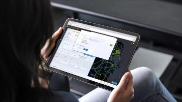 Woman holding a tablet and using the Navisphere application.